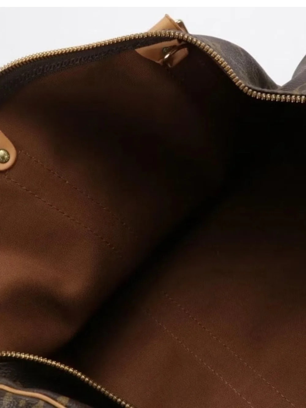 The Louis Vuitton Keepall Bandoulière 50 features iconic Monogram Canvas and Vac